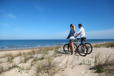 A couple on the beach on Port Aransas bike rental.